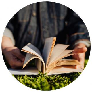 Buch auf Wiese. Link zu unserem Onlineschaufenster Geschichten für ein Wochenende.